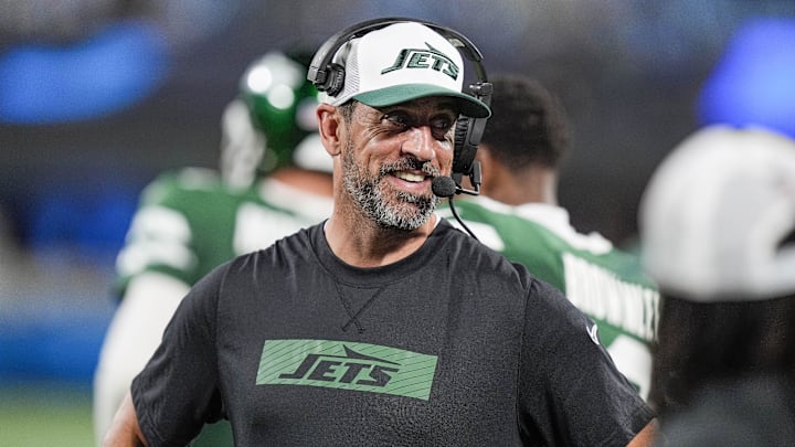 Aug 17, 2024; Charlotte, North Carolina, USA;  New York Jets quarterback Aaron Rodgers (8) shares a laugh on the sidelines during the second half against the Carolina Panthers at Bank of America Stadium. Mandatory Credit: Jim Dedmon-Imagn Images