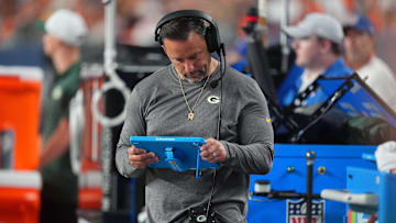 Aug 18, 2024; Denver, Colorado, USA; Green Bay Packers linebackers coach Anthony Campanile looks at a tablet in the second half against the Denver Broncos at Empower Field at Mile High. Mandatory Credit: Ron Chenoy-Imagn Images