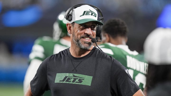 Aug 17, 2024; Charlotte, North Carolina, USA; New York Jets quarterback Aaron Rodgers (8) shares a laugh on the sidelines during the second half against the Carolina Panthers at Bank of America Stadium. 