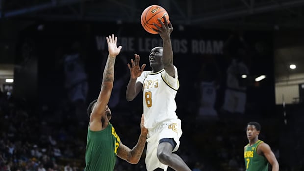 Colorado Buffaloes forward Bangot Dak (8) shoots the ball over Baylor Bears guard Langston Love (13)  in the second half at t