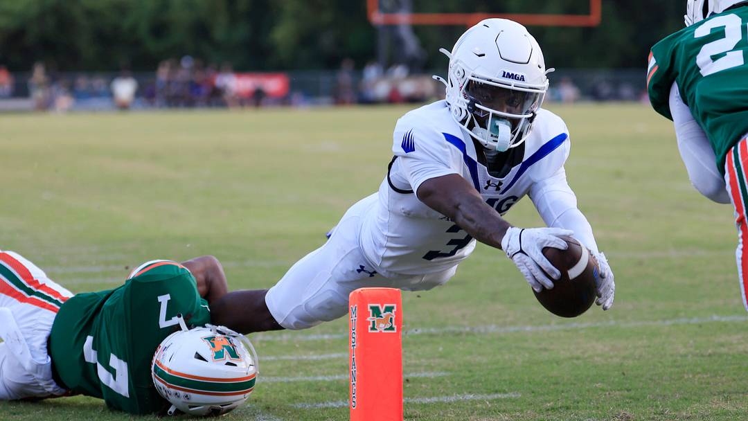 IMG Academy's Eric McFarland (3) scores a rushing touchdown against Mandarin's Tamajh Mitchell (7) during the first quarter of a high school football matchup at Mandarin High School, Friday, Sept. 19, 2025, in Jacksonville, Fla. The IMG Academy Ascenders defeated the Mandarin Mustangs 57-7.
