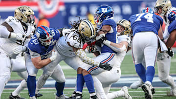 Dec 8, 2024; East Rutherford, New Jersey, USA; New York Giants running back Tyrone Tracy Jr. (29) is tackled by New Orleans Saints linebacker Demario Davis (56) and linebacker Pete Werner (20) during the second half at MetLife Stadium. Mandatory Credit: Vincent Carchietta-Imagn Images
