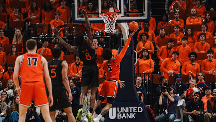 Feb 21, 2026; Charlottesville, Virginia, USA; Virginia Cavaliers guard Sam Lewis (5) shoots the ball while Miami (FL) Hurricanes center Ernest Udeh Jr. (8) defends during the first half at John Paul Jones Arena. Mandatory Credit: Emily Faith Morgan-Imagn Images