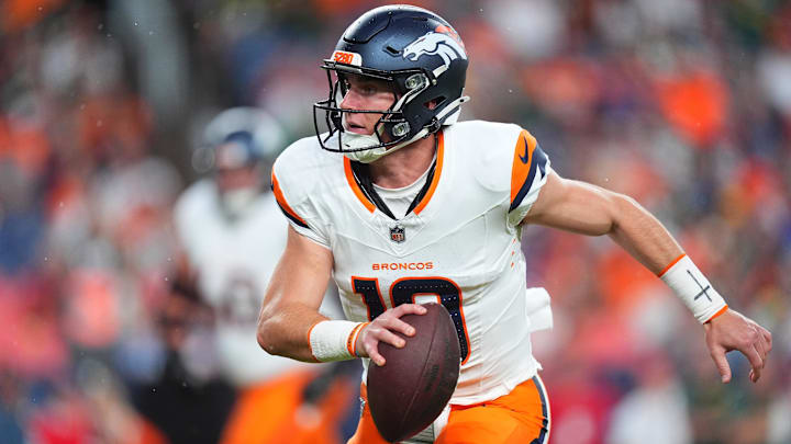 Aug 18, 2024; Denver, Colorado, USA; Denver Broncos quarterback Bo Nix (10) scrambles with the ball in the first quarter against the Green Bay Packers at Empower Field at Mile High. 