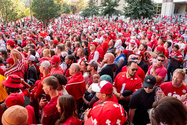 Nebraska Cornhuskers fans watch the team arrive before the game against the Colorado Buffaloes at Memorial Stadium.