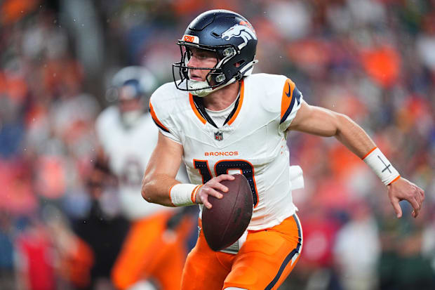 Denver Broncos quarterback Bo Nix (10) scrambles with the ball in the first quarter against the Green Bay Packers.