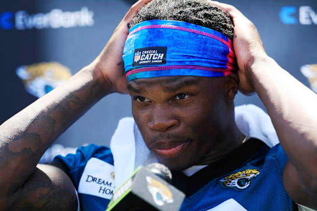 Jacksonville Jaguars wide receiver Travis Hunter (12) adjusts his headband before speaking to members of the media during the