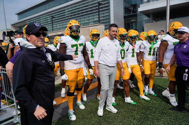 Oregon Ducks head coach Dan Lanning leads his team on the field against the Northwestern Wildcats at Northwestern Medicine Fi