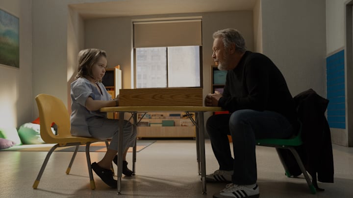 Jacobi Jupe and Billy Crystal sit across from each other at a small table