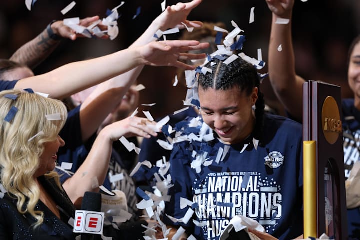 Connecticut Huskies guard Azzi Fudd gets confettied by her teammates while interviewed by ESPN reporter Holly Rowe.