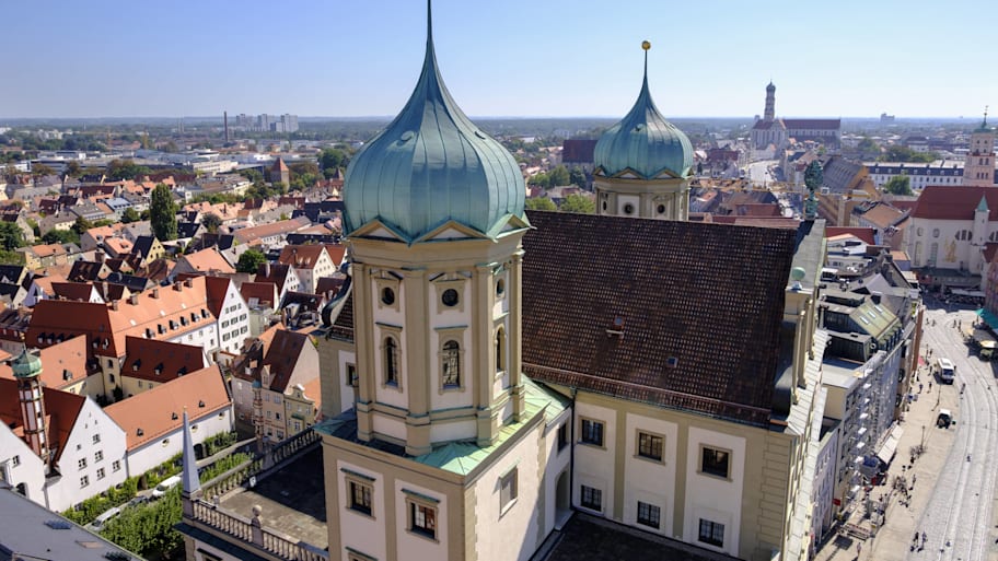 Staying in Augsburg would be cheaper than staying in Munich.