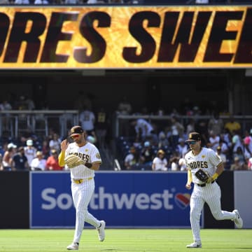 Jun 26, 2024; San Diego, California, USA; San Diego Padres left fielder Tyler Wade (14) and right fielder Bryce Johnson (27) run off the field after defeating the Washington Nationals at Petco Park. Mandatory Credit: Orlando Ramirez-USA TODAY Sports