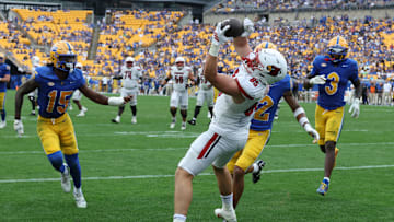 Sep 27, 2025; Pittsburgh, Pennsylvania, USA;  Louisville Cardinals tight end Nate Kurisky (85) catches a touchdown pass behind Pittsburgh Panthers defensive backs Rashad Battle (15) and Cruce Brookins (12) during the fourth quarter at Acrisure Stadium. Mandatory Credit: Charles LeClaire-Imagn Images