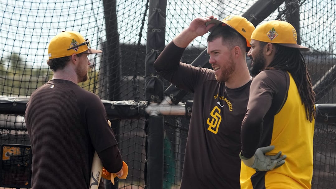 Padres left fielder Gavin Sheets (30), right fielder Fernando Tatis Jr. (23) and second baseman Jake Cronenworth (9) talk during spring training camp on Feb. 15, 2026.