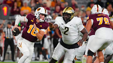 ASU quarterback Sam Leavitt (10) scrambles against UCF defensive tackle Lee Hunter (2) during a game at Mountain America Stadium in Tempe on Nov. 9, 2024.