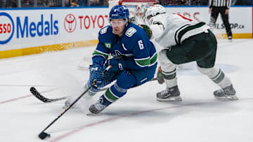 Apr 12, 2025; Vancouver, British Columbia, CAN; Minnesota Wild forward Matt Boldy (12) checks Vancouver Canucks forward Brock Boeser (6) in overtime at Rogers Arena. Mandatory Credit: Bob Frid-Imagn Images