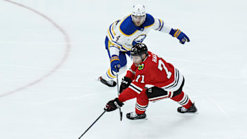Oct 19, 2024; Chicago, Illinois, USA;  Buffalo Sabres defenseman Bowen Byram (4) and Chicago Blackhawks left wing Taylor Hall (71) chase the puck during the third period at the United Center. Mandatory Credit: Matt Marton-Imagn Images