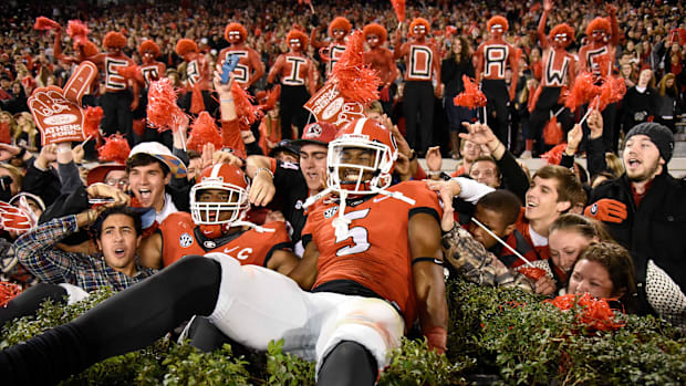 Georgia Bulldogs defensive end Josh Dawson (91) and wide receiver Terry Godwin (5) jumped into the hedges at Sanford Stadium.