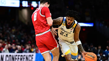 Mar 21, 2025; Cleveland, OH, USA; Marquette Golden Eagles forward David Joplin (23) dribbles the ball defended by New Mexico Lobos forward Filip Borovicanin (8).