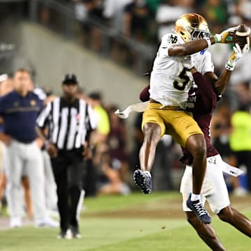 Aug 31, 2024; College Station, Texas, USA; Notre Dame Fighting Irish wide receiver Beaux Collins (5) catches a pass as Texas A&M Aggies defensive back Dashawn Fillmore (26) attempts to break up the play in the fourth quarter at Kyle Field. Mandatory Credit: Maria Lysaker-Imagn Images