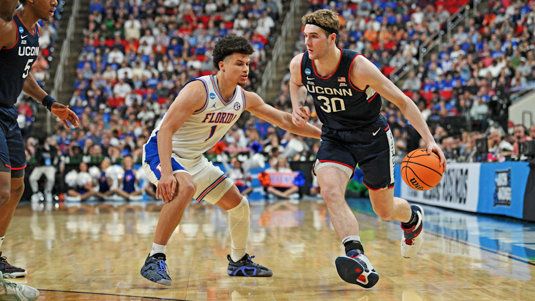 Mar 23, 2025; Raleigh, NC, USA; Connecticut Huskies forward Liam McNeeley (30) drives to the basket during the second half against Florida Gators guard Walter Clayton Jr. (1) in the second round of the NCAA Tournament at Lenovo Center. Mandatory Credit: Zachary Taft-Imagn Images