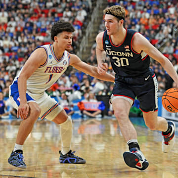 Mar 23, 2025; Raleigh, NC, USA; Connecticut Huskies forward Liam McNeeley (30) drives to the basket during the second half against Florida Gators guard Walter Clayton Jr. (1) in the second round of the NCAA Tournament at Lenovo Center. Mandatory Credit: Zachary Taft-Imagn Images