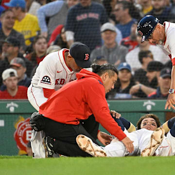 Boston Red Sox first baseman Triston Casas is attended to by coaching and medical staff against the Minnesota Twins.