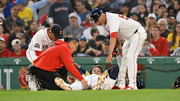 Triston Casas (36) is attended to by coaching and medical staff during the second inning against the Minnesota Twins at Fenway Park. 