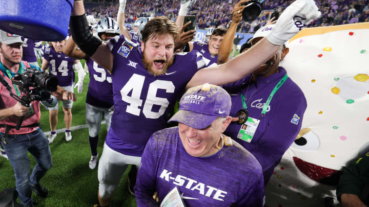 Dec 28, 2023; Orlando, FL, USA;  Kansas State Wildcats head coach Chris Klieman is congratulated by Kansas State Wildcats defensive end Jace Friesen (46) after beating North Carolina State Wolfpack in the Pop-Tarts bowl at Camping World Stadium. Mandatory Credit: Nathan Ray Seebeck-USA TODAY Sports