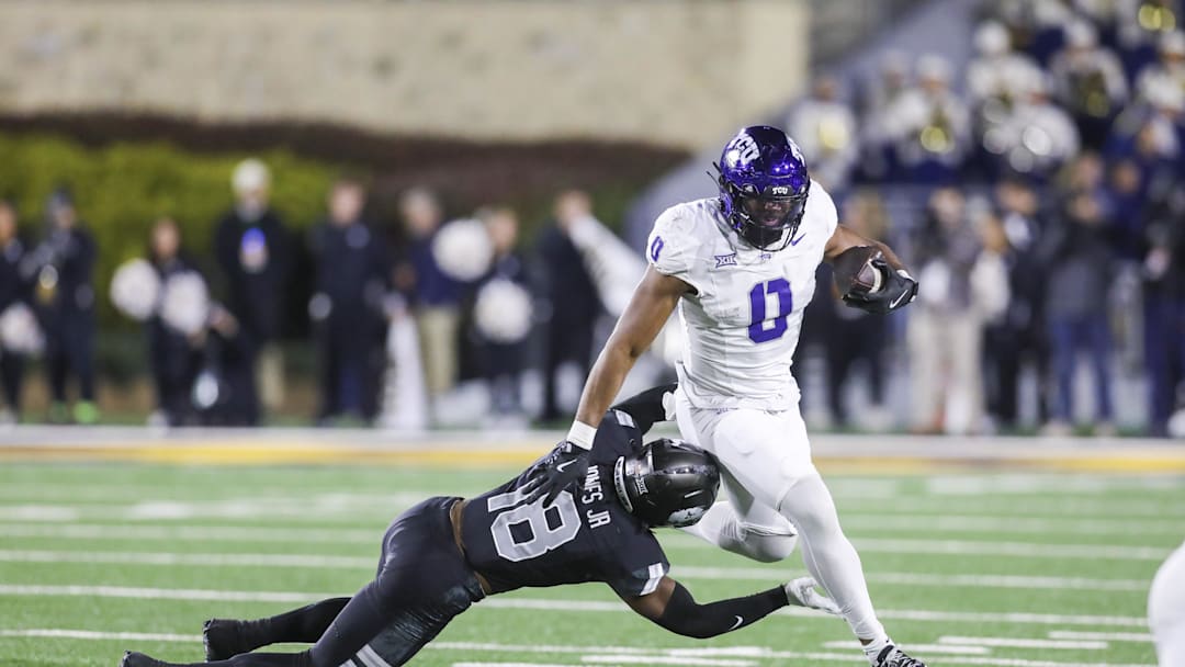 Oct 25, 2025; Morgantown, West Virginia, USA; Texas Christian University Horned Frogs tight end DJ Rogers (0) makes a catch and shakes a tackle from West Virginia Mountaineers linebacker Curtis Jones Jr. (18) during the fourth quarter at Milan Puskar Stadium. Mandatory Credit: Ben Queen-Imagn Images