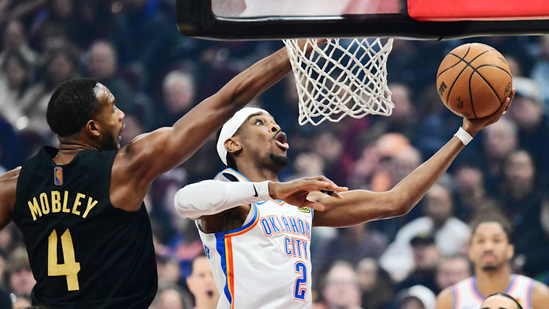 Jan 19, 2026; Cleveland, Ohio, USA; Oklahoma City Thunder guard Shai Gilgeous-Alexander (2) drives to the basket against Cleveland Cavaliers center Evan Mobley (4) during the first quarter at Rocket Arena. Mandatory Credit: Ken Blaze-Imagn Images