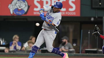 Apr 19, 2025; Arlington, Texas, USA; Los Angeles Dodgers designated hitter Eddie Rosario (9) singles against the Texas Rangers during the third inning at Globe Life Field. Mandatory Credit: Jim Cowsert-Imagn Images