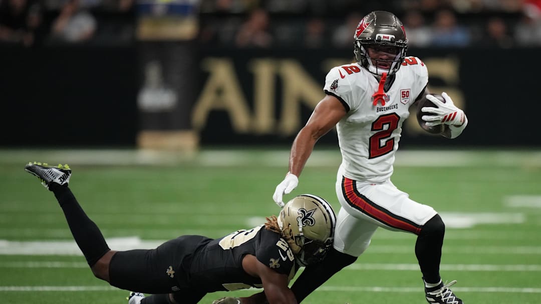 Oct 26, 2025; New Orleans, Louisiana, USA;  Tampa Bay Buccaneers wide receiver Emeka Egbuka (2) runs for a gain past New Orleans Saints cornerback Quincy Riley (29) during the third quarter at Caesars Superdome. Mandatory Credit: Matthew Hinton-Imagn Images