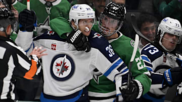 Apr 10, 2025; Dallas, Texas, USA; Dallas Stars left wing Mason Marchment (27) holds back Winnipeg Jets center Morgan Barron (36) during the first period at the American Airlines Center. Mandatory Credit: Jerome Miron-Imagn Images