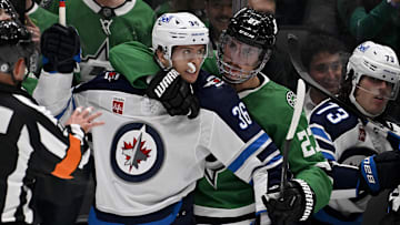 Apr 10, 2025; Dallas, Texas, USA; Dallas Stars left wing Mason Marchment (27) holds back Winnipeg Jets center Morgan Barron (36) during the first period at the American Airlines Center. Mandatory Credit: Jerome Miron-Imagn Images