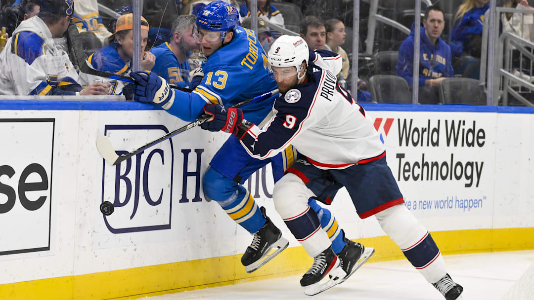 Jan 11, 2025; St. Louis, Missouri, USA;  St. Louis Blues right wing Alexey Toropchenko (13) and Columbus Blue Jackets defenseman Ivan Provorov (9)  battle for the puck during the second period at Enterprise Center. Mandatory Credit: Jeff Curry-Imagn Images