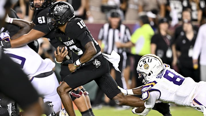 Oct 26, 2024; College Station, Texas, USA; Texas A&M Aggies quarterback Marcel Reed (10) runs the ball in the fourth quarter as LSU Tigers safety Major Burns (8) lunges to attempt a tackle at Kyle Field. Mandatory Credit: Maria Lysaker-Imagn Images. 