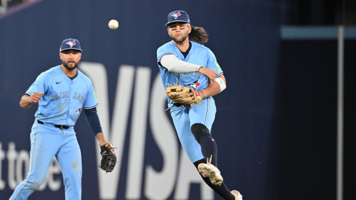 Jun 14, 2024; Toronto, Ontario, CAN;  Toronto Blue Jays shortstop Bo Bichette (11) throws to first base to force out Cleveland Guardians right fielder Will Brennan (not shown) as Jays second baseman Isiah Kiner-Falefa (7) looks on in the eighth inning at Rogers Centre.