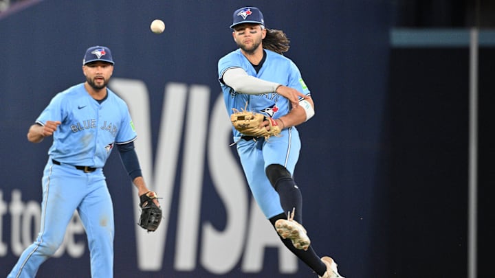 Jun 14, 2024; Toronto, Ontario, CAN;  Toronto Blue Jays shortstop Bo Bichette (11) throws to first base to force out Cleveland Guardians right fielder Will Brennan (not shown) as Jays second baseman Isiah Kiner-Falefa (7) looks on in the eighth inning at Rogers Centre. Mandatory Credit: Dan Hamilton-Imagn Images
