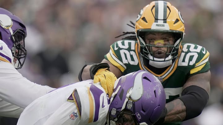Minnesota Vikings' J.J. McCarthy (9) evades a sack by Green Bay Packers defensive end Rashan Gary (52) during the fourth quarter of their game Sunday, November 23, 2025, at Lambeau Field in Green Bay, Wisconsin.
