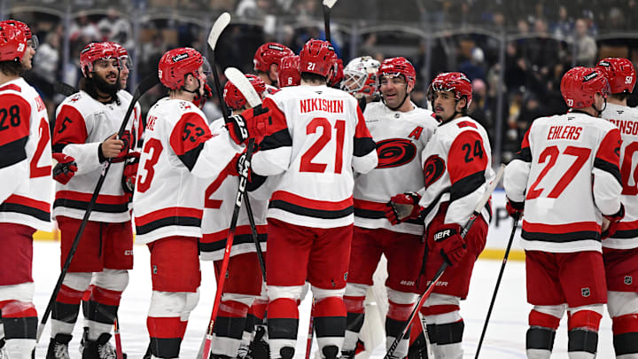 Mar 20, 2026; Toronto, Ontario, CAN;  Carolina Hurricanes defenseman Alexander Nikishin (21) is congratulated by team mates after scoring the winning goal in overtime against the Toronto Maple Leafs at Scotiabank Arena. Mandatory Credit: Dan Hamilton-Imagn Images