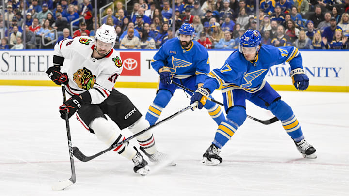 Mar 22, 2025; St. Louis, Missouri, USA;  Chicago Blackhawks center Jason Dickinson (16) controls the puck as St. Louis Blues defenseman Cam Fowler (17) defends during the first period at Enterprise Center. Mandatory Credit: Jeff Curry-Imagn Images