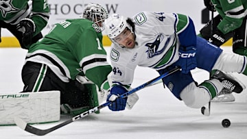 Apr 8, 2025; Dallas, Texas, USA; Vancouver Canucks left wing Kiefer Sherwood (44) attempts to poke the puck past Dallas Stars goaltender Casey DeSmith (1) during the first period at the American Airlines Center. Mandatory Credit: Jerome Miron-Imagn Images
