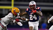 Andrew Henry of New Mexico stiff-arms defensive back Shamari Simmons of Arizona State in the Shrine Bowl. 