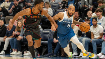 Apr 9, 2024; Minneapolis, Minnesota, USA; Minnesota Timberwolves guard Jordan McLaughlin (6) drives on Washington Wizards guard Jared Butler (4) in the third quarter at Target Center. Mandatory Credit: Matt Blewett-USA TODAY Sports