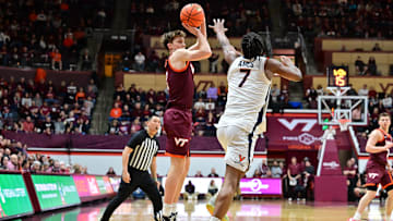 Feb 15, 2025; Blacksburg, Virginia, USA; Virginia Tech Hokies guard Jaden Schutt (2) shoots the ball as Virginia Cavaliers guard Dai Dai Ames (7) defends during the first half at Cassell Coliseum. Mandatory Credit: Brian Bishop-Imagn Images