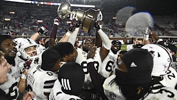 Nov 24, 2022; Oxford, Mississippi, USA; Mississippi State Bulldogs players celebrate with the Egg Bowl trophy after the game against the Ole Miss Rebels at Vaught-Hemingway Stadium. Mandatory Credit: Matt Bush-Imagn Images