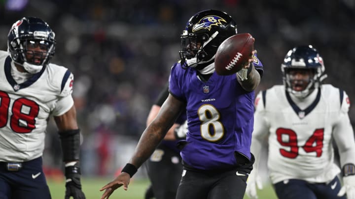 Jan 20, 2024; Baltimore, MD, USA; Baltimore Ravens quarterback Lamar Jackson (8) runs the ball to score a touchdown against Houston Texans defensive tackle Sheldon Rankins (98) and defensive tackle Khalil Davis (94) during the fourth quarter of a 2024 AFC divisional round game at M&T Bank Stadium. Mandatory Credit: Tommy Gilligan-USA TODAY Sports