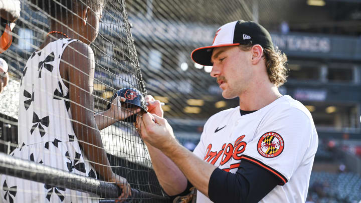 Jun 24, 2024; Baltimore, Maryland, USA;  Baltimore Orioles shortstop Gunnar Henderson (2) signs an autograph for a young fan before the game against the Cleveland Guardians at Oriole Park at Camden Yards. 