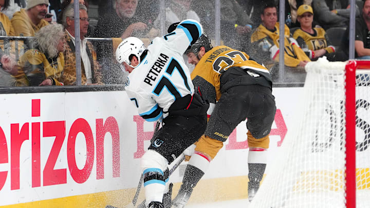 Apr 29, 2026; Las Vegas, Nevada, USA; Utah Mammoth right wing JJ Peterka (77) reaches the puck before Vegas Golden Knights defenseman Shea Theodore (27) during the second period of game five of the first round of the 2026 Stanley Cup Playoffs at T-Mobile Arena. Mandatory Credit: Stephen R. Sylvanie-Imagn Images